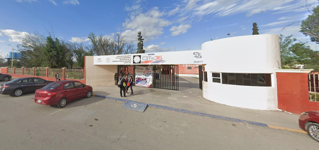 Fotografía en la que se muestra la entrada del plantel, conformada por una rampa por la que se puede ingresar y una reja de color negro. Encima de la reja hay una placa en la que en letras grandes dice Cebetis 36. 